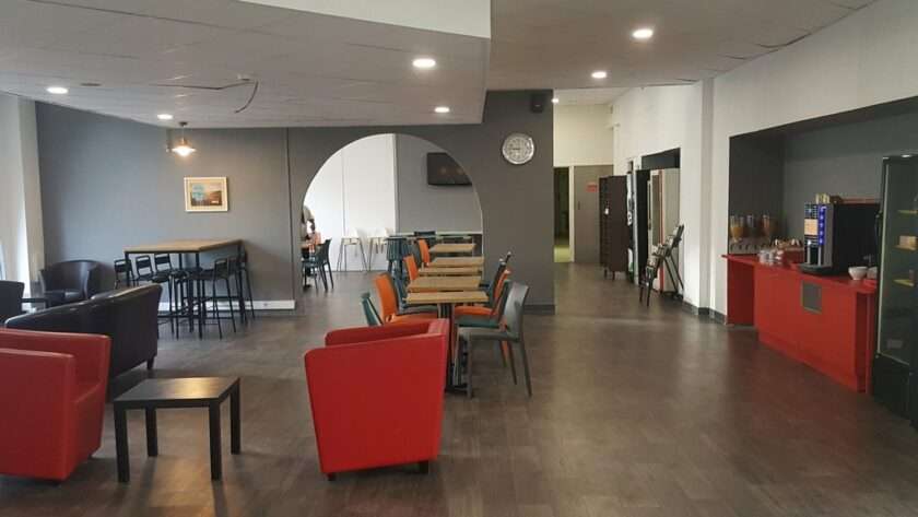 Les tables d'un hôtel avec une machine à café à disposition