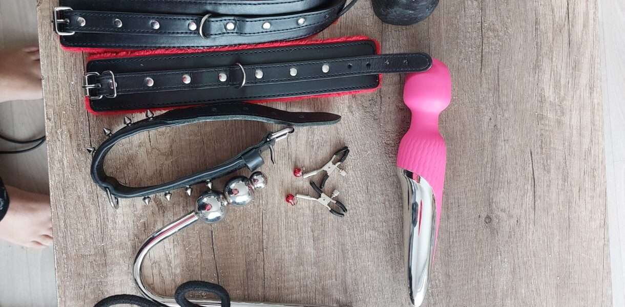 Une photo des jouets sexuels de Lili Soumise : une corde noire, un collier, un Wand, des pince tétons, des entraves et un gode