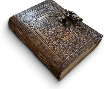 Une photo représentant un cahier en cuir pouvant se fermer avec des dessins de style gothique.