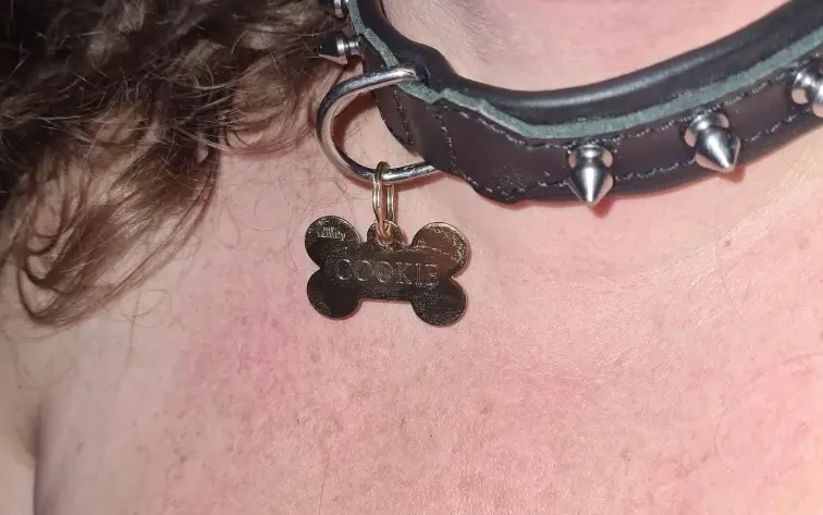 Le cou de Lili soumise avec un collier à picots et une médaille Cookie