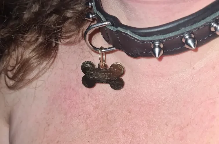Le cou de Lili soumise avec un collier à picots et une médaille Cookie